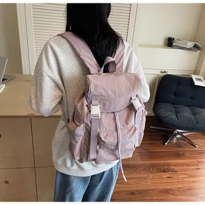 Détail du sac à dos en nylon rose pâle avec fermeture à rabat et cordons de serrage