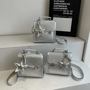 Three silver glitter mini handbags with star charms on white marble in a modern display