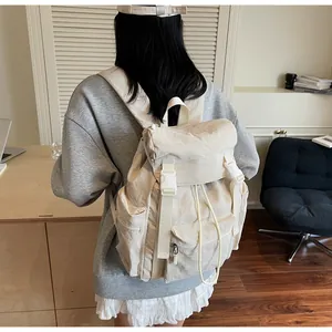 Détail d'un sac à dos en nylon blanc crème avec sangles à boucle et poches sur un mannequin