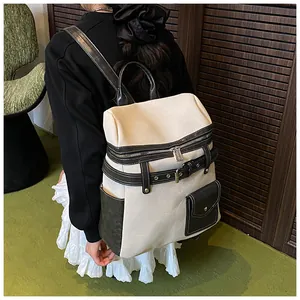 Detail view of large canvas and leather backpack with decorative metal buckle straps