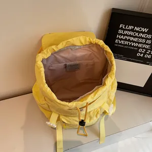 Sac à dos décontracté jaune vif en nylon avec fermeture à cordon et boucle sur marbre