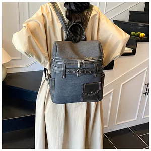 Rear view of a model wearing a grey canvas and black leather vintage backpack on stairs
