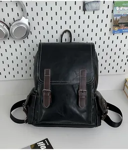 Detail of vintage black leather backpack with brown buckle straps and white contrast stitching