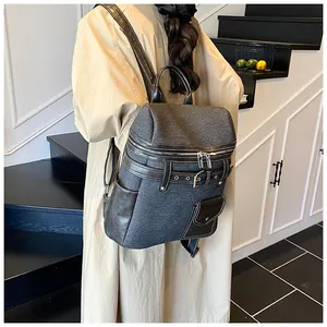 Detail view of large dark gray vintage backpack with leather trim on indoor steps