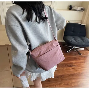 Detailed back view of a pink nylon crossbody bag showing its large capacity and texture