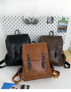 Three vintage leather backpacks in black, dark brown, and caramel colors on a display