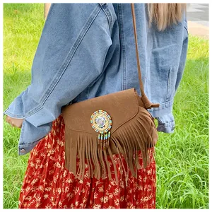 Détail du sac bandoulière en daim marron avec perles colorées et longues franges bohèmes