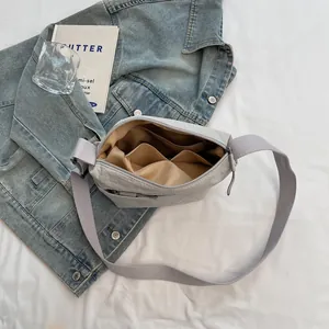 Light grey nylon crossbody bag with spacious interior pockets and durable wide strap
