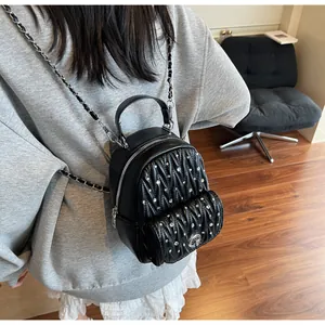 Détail d'un mini sac à dos matelassé noir orné de strass et de bretelles en chaîne argentée
