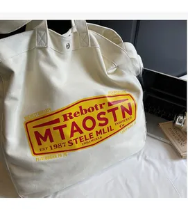Detail view of large white canvas tote bag with retro stamp print and dual carry straps