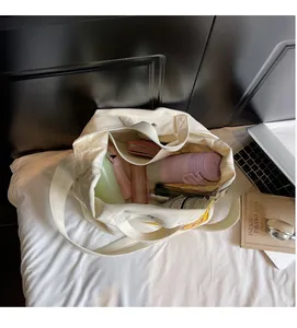 Spacious interior of beige canvas tote bag showing storage for umbrella and books