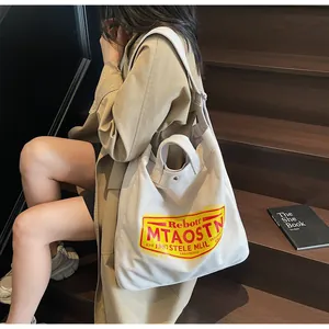 Detail of a large beige canvas tote bag with retro logo on vintage wooden stairs
