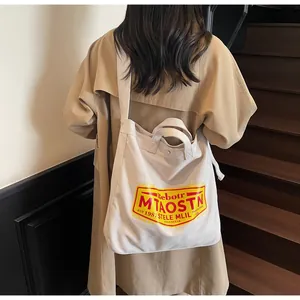 Detailed back view of a cream canvas tote bag with retro print on a casual trench coat