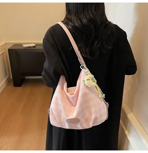 Détail du sac cabas en toile à carreaux roses avec texture souple et gri-gri lune jaune