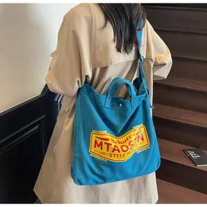 Detail of teal canvas tote bag featuring vintage print and adjustable shoulder strap