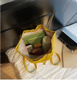 Detail view of large capacity yellow drawstring backpack interior with daily items