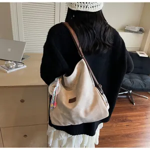 Detail of off-white oversized hobo bag with leather logo patch and colorful beads