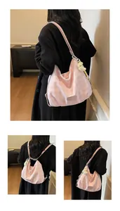 Détail du sac bandoulière à carreaux rose avec tissu plissé et pendentif jaune