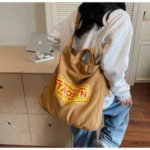 Detailed view of heavy canvas tote with yellow vintage graphic and crossbody strap