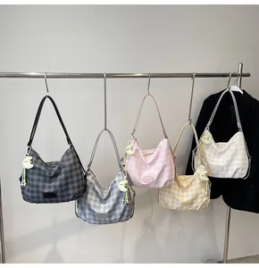 Détail de sacs fourre-tout à carreaux colorés avec des charms en peluche lune