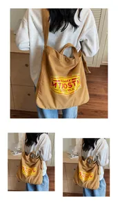 Detailed close-up of a large capacity ochre canvas tote bag with vintage print