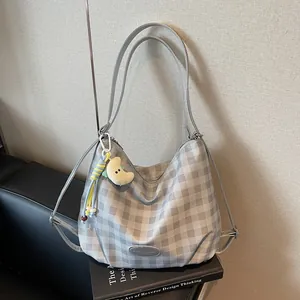 Sac fourre-tout à carreaux gris et blanc avec charm croissant de lune sur canapé