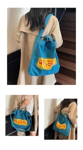Close-up of blue canvas tote bag with vintage yellow label and dual-strap detail