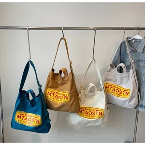 Close-up of canvas tote bags in blue, beige, and brown with vintage graphic prints