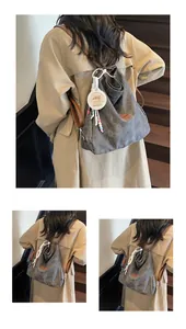 Detail of grey canvas tote bag with brown leather straps and Capybara charm