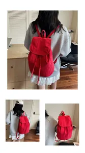 Detail of red drawstring canvas backpack showing back and side view on model