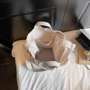 Off-white canvas tote bag with large capacity and multi-pocket interior design