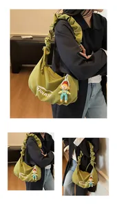 Detail of green canvas crossbody bag with ruffled strap and BANATA logo print