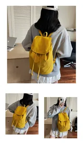 Detail view of bright yellow canvas drawstring backpack with stylish flap and strap closure