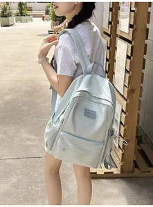 Detail of mint green school backpack with drawstring side pockets and brand label