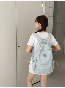 Side view of a mint green minimalist nylon backpack showing side drawstring pockets