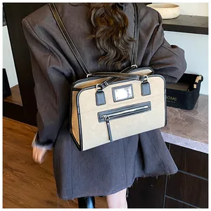 Retro khaki dual-use backpack with black trim and silver hardware shown on model