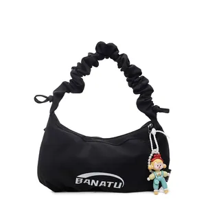 Minimalist black crescent shoulder bag with pleated handle and cute doll pendant