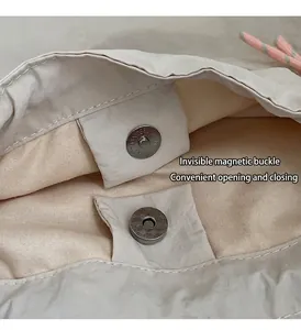 Detail of hidden magnetic buckle on embroidered tote bag for convenient closure