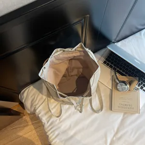 Minimalist beige drawstring backpack with spacious main compartment for laptop and books