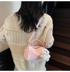 Bolso Boston rosa con acabado texturizado, charm de osito de peluche y correa ajustable