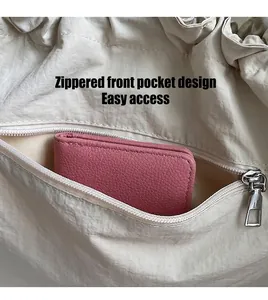 Detailed close-up of the front zipper pocket with pink wallet for functional storage display