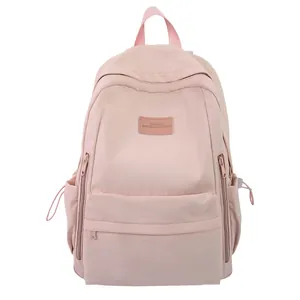 Minimalist light pink nylon backpack for students featuring front zipper pocket and side pockets