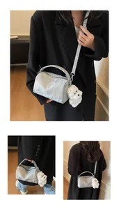 Detalle del bolso Boston jaspeado plata con correa de logo y colgante de peluche