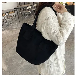 Détails du sac fourre-tout noir en texture suédine avec rabats de poche symétriques