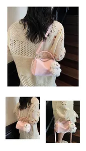 Detalle del bolso Boston rosa con texto grabado y lindo colgante de perro de peluche