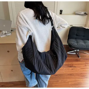 Detailed view of black pleated hobo bag in large capacity with wide shoulder strap