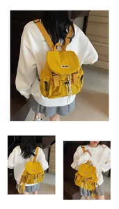 Vue détaillée du sac à dos en nylon jaune avec rabat et poche latérale à fermeture éclair