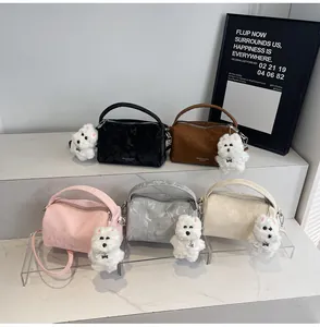 Vista detallada de cinco bolsos Boston con textura de mármol y colgantes de perro de peluche