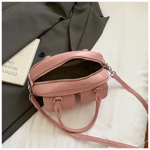 Pink glossy leather bowling bag featuring functional front pockets and metal zipper closure