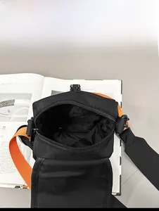 Innenansicht der schwarzen Nylon-Umhängetasche mit leuchtend orangem Gurt